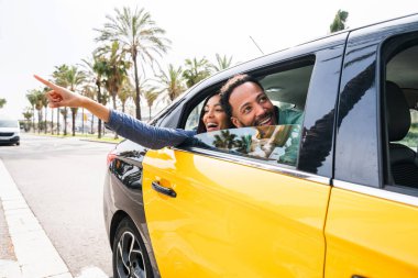 Güzel, mutlu Latin aşıklar Barselona 'da turistler yaz tatilinde eğleniyor ve taksiye biniyor.