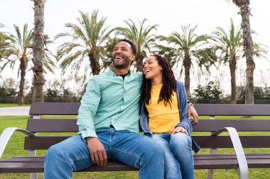 Güzel, mutlu Latin aşıklar, Barselona 'da yaz tatilinde eğlenen turistler, insanlar kaynaşıyor ve parkta bir bankta oturuyor.