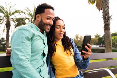 Güzel, mutlu Latin aşıklar, Barselona 'da yaz tatilinde eğlenen turistler, insanlar kaynaşıyor ve parkta bir bankta oturuyor.