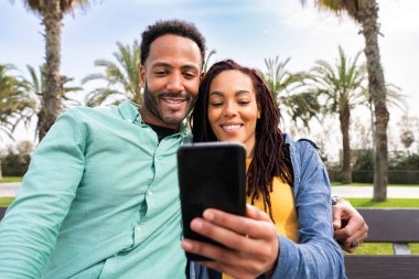 Güzel, mutlu Latin aşıklar, Barselona 'da yaz tatilinde eğlenen turistler, insanlar kaynaşıyor ve parkta bir bankta oturuyor.