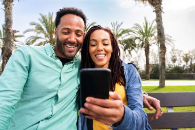 Güzel, mutlu Latin aşıklar, Barselona 'da yaz tatilinde eğlenen turistler, insanlar kaynaşıyor ve parkta bir bankta oturuyor.