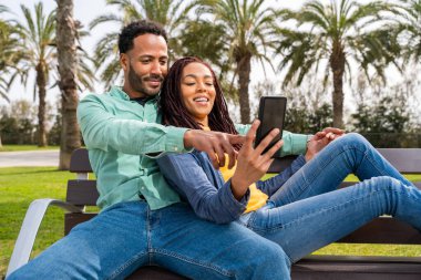 Güzel, mutlu Latin aşıklar, Barselona 'da yaz tatilinde eğlenen turistler, insanlar kaynaşıyor ve parkta bir bankta oturuyor.
