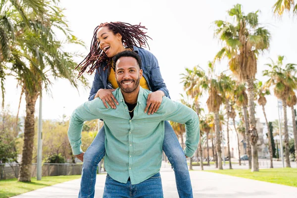 Güzel, mutlu Latin sevgililer, Barselona 'da yaz tatilinde eğlenen turistler, tropik palmiye ağaçlarıyla dolu bir parkta kaynaşan insanlar.