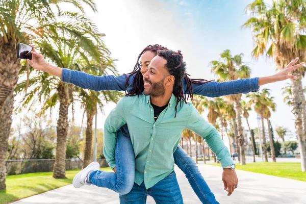 美丽而快乐的拉蒂诺一对恋人在户外约会 巴塞罗那的游客们在暑假里玩得很开心 人们在公园里与热带棕榈树相亲相爱 — 图库照片
