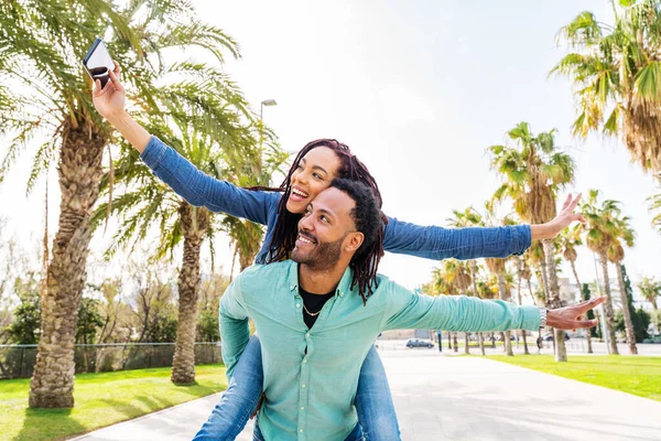 屋外でデート愛好家の美しい幸せなパニックラテンカップル 夏休み中にバルセロナの観光客 熱帯のヤシの木と公園で結合人々 — ストック写真