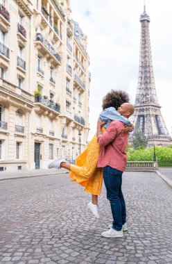 Paris şehir merkezini ve Eyfel Kulesi 'ni ziyaret eden siyah mutlu çift - Afrika kökenli Amerikalı turistler Avrupa' da seyahat ediyor ve açık havada flört ediyorlar