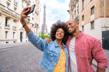 Paris şehir merkezini ve Eyfel Kulesi 'ni ziyaret eden siyah mutlu çift - Afrika kökenli Amerikalı turistler Avrupa' da seyahat ediyor ve açık havada flört ediyorlar