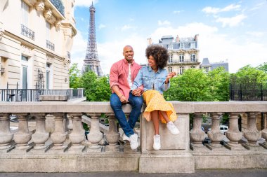 Paris şehir merkezini ve Eyfel Kulesi 'ni ziyaret eden siyah mutlu çift - Afrika kökenli Amerikalı turistler Avrupa' da seyahat ediyor ve açık havada flört ediyorlar