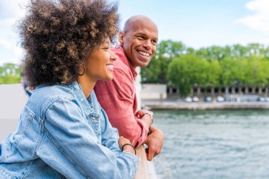 Paris şehir merkezini ve Eyfel Kulesi 'ni ziyaret eden siyah mutlu çift - Afrika kökenli Amerikalı turistler Avrupa' da seyahat ediyor ve açık havada flört ediyorlar