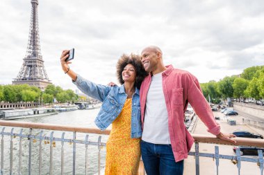 Paris şehir merkezini ve Eyfel Kulesi 'ni ziyaret eden siyah mutlu çift - Afrika kökenli Amerikalı turistler Avrupa' da seyahat ediyor ve açık havada flört ediyorlar