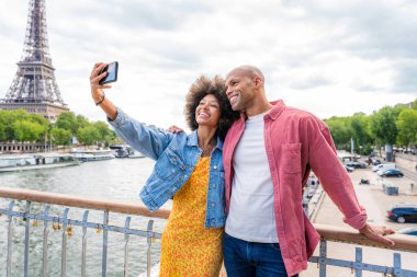 Paris şehir merkezini ve Eyfel Kulesi 'ni ziyaret eden siyah mutlu çift - Afrika kökenli Amerikalı turistler Avrupa' da seyahat ediyor ve açık havada flört ediyorlar