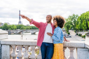 Paris şehir merkezini ve Eyfel Kulesi 'ni ziyaret eden siyah mutlu çift - Afrika kökenli Amerikalı turistler Avrupa' da seyahat ediyor ve açık havada flört ediyorlar