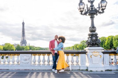Paris şehir merkezini ve Eyfel Kulesi 'ni ziyaret eden siyah mutlu çift - Afrika kökenli Amerikalı turistler Avrupa' da seyahat ediyor ve açık havada flört ediyorlar
