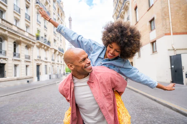 Black cheerful happy couple in love visiting Paris city centre and Eiffel Tower - African american tourists travelling in Europe and dating outdoors