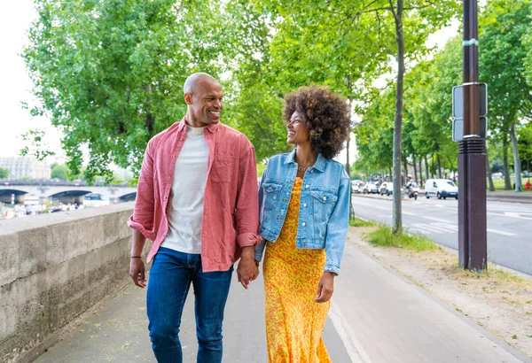 Black cheerful happy couple in love visiting Paris city centre and Eiffel Tower - African american tourists travelling in Europe and dating outdoors