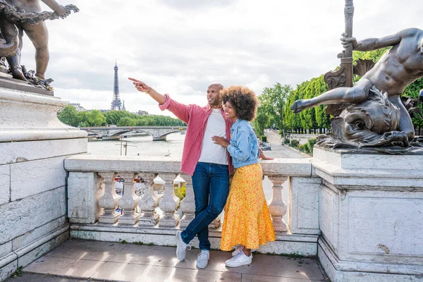 Paris şehir merkezini ve Eyfel Kulesi 'ni ziyaret eden siyah mutlu çift - Afrika kökenli Amerikalı turistler Avrupa' da seyahat ediyor ve açık havada flört ediyorlar