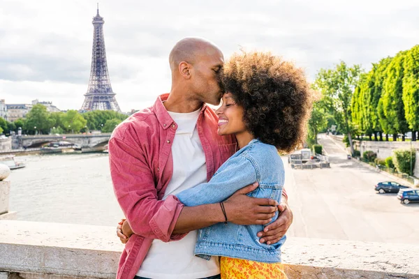 Black cheerful happy couple in love visiting Paris city centre and Eiffel Tower - African american tourists travelling in Europe and dating outdoors