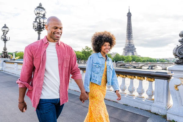 Paris şehir merkezini ve Eyfel Kulesi 'ni ziyaret eden siyah mutlu çift - Afrika kökenli Amerikalı turistler Avrupa' da seyahat ediyor ve açık havada flört ediyorlar