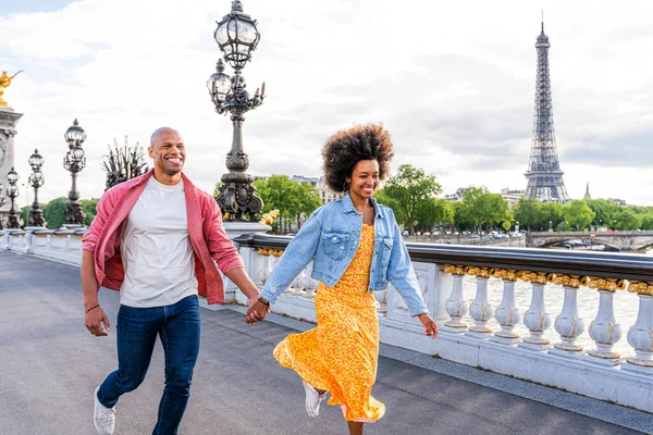 Paris şehir merkezini ve Eyfel Kulesi 'ni ziyaret eden siyah mutlu çift - Afrika kökenli Amerikalı turistler Avrupa' da seyahat ediyor ve açık havada flört ediyorlar