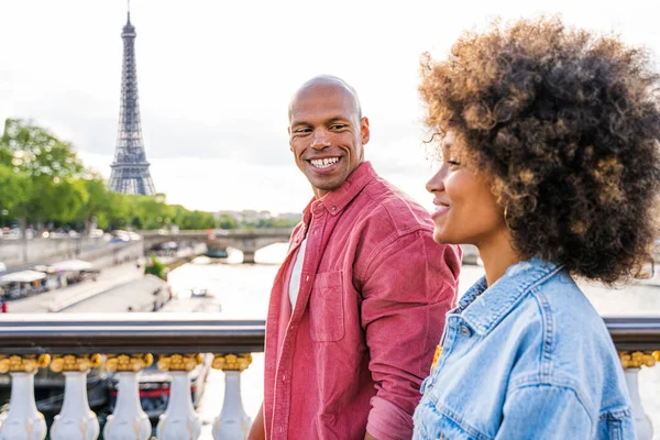 Black cheerful happy couple in love visiting Paris city centre and Eiffel Tower - African american tourists travelling in Europe and dating outdoors