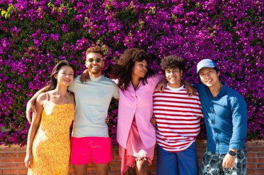 Multiethnic group of young happy friends bonding outside, having fun on summertime vacation - Multicultural cheerful people with summer clothes enjoying summer holidays, concepts about youth, friendship and positive emotion