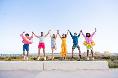Multiethnic group of young happy friends bonding outside, having fun on summertime vacation - Multicultural cheerful people with summer clothes enjoying summer holidays, concepts about youth, friendship and positive emotion