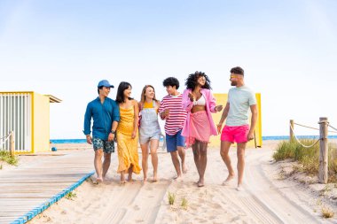 Multiethnic group of young happy friends bonding outside, having fun on summertime vacation - Multicultural cheerful people with summer clothes enjoying summer holidays, concepts about youth, friendship and positive emotion