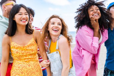 Multiethnic group of young happy friends bonding outside, having fun on summertime vacation - Multicultural cheerful people with summer clothes enjoying summer holidays, concepts about youth, friendship and positive emotion