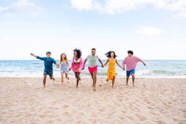 Multiethnic group of young happy friends bonding outside, having fun on summertime vacation - Multicultural cheerful people with summer clothes enjoying summer holidays, concepts about youth, friendship and positive emotion