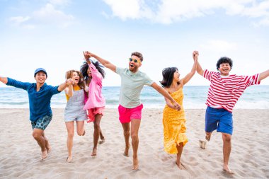 Multiethnic group of young happy friends bonding outside, having fun on summertime vacation - Multicultural cheerful people with summer clothes enjoying summer holidays, concepts about youth, friendship and positive emotion
