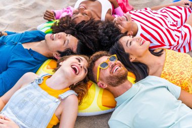 Multiethnic group of young happy friends bonding outside, having fun on summertime vacation - Multicultural cheerful people with summer clothes enjoying summer holidays, concepts about youth, friendship and positive emotion
