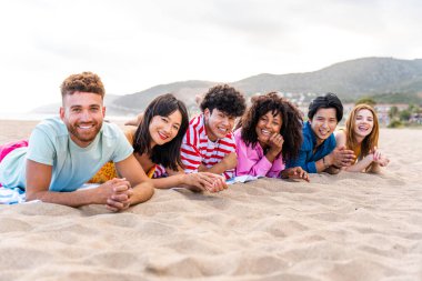 Multiethnic group of young happy friends bonding outside, having fun on summertime vacation - Multicultural cheerful people with summer clothes enjoying summer holidays, concepts about youth, friendship and positive emotion