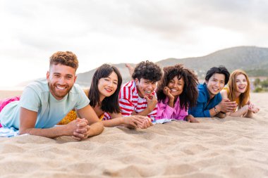 Multiethnic group of young happy friends bonding outside, having fun on summertime vacation - Multicultural cheerful people with summer clothes enjoying summer holidays, concepts about youth, friendship and positive emotion
