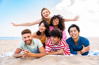 Multiethnic group of young happy friends bonding outside, having fun on summertime vacation - Multicultural cheerful people with summer clothes enjoying summer holidays, concepts about youth, friendship and positive emotion