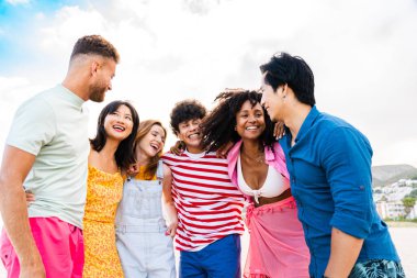 Multiethnic group of young happy friends bonding outside, having fun on summertime vacation - Multicultural cheerful people with summer clothes enjoying summer holidays, concepts about youth, friendship and positive emotion