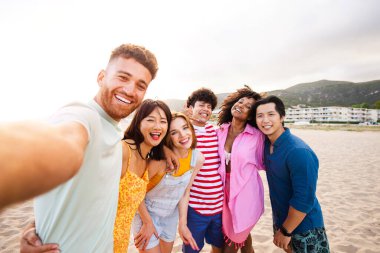 Multiethnic group of young happy friends bonding outside, having fun on summertime vacation - Multicultural cheerful people with summer clothes enjoying summer holidays, concepts about youth, friendship and positive emotion