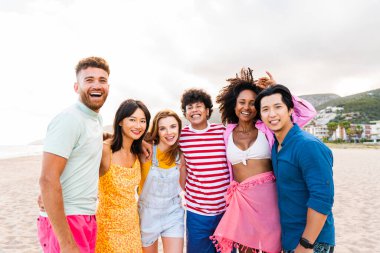 Multiethnic group of young happy friends bonding outside, having fun on summertime vacation - Multicultural cheerful people with summer clothes enjoying summer holidays, concepts about youth, friendship and positive emotion