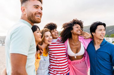 Multiethnic group of young happy friends bonding outside, having fun on summertime vacation - Multicultural cheerful people with summer clothes enjoying summer holidays, concepts about youth, friendship and positive emotion