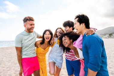 Multiethnic group of young happy friends bonding outside, having fun on summertime vacation - Multicultural cheerful people with summer clothes enjoying summer holidays, concepts about youth, friendship and positive emotion