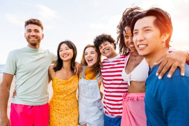 Multiethnic group of young happy friends bonding outside, having fun on summertime vacation - Multicultural cheerful people with summer clothes enjoying summer holidays, concepts about youth, friendship and positive emotion