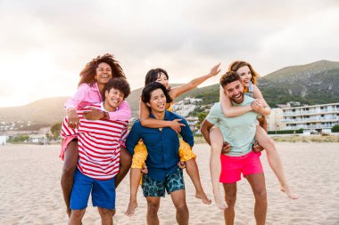 Multiethnic group of young happy friends bonding outside, having fun on summertime vacation - Multicultural cheerful people with summer clothes enjoying summer holidays, concepts about youth, friendship and positive emotion