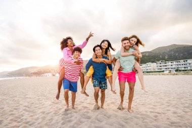 Multiethnic group of young happy friends bonding outside, having fun on summertime vacation - Multicultural cheerful people with summer clothes enjoying summer holidays, concepts about youth, friendship and positive emotion