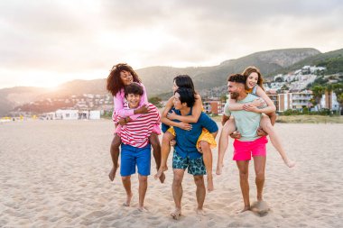 Multiethnic group of young happy friends bonding outside, having fun on summertime vacation - Multicultural cheerful people with summer clothes enjoying summer holidays, concepts about youth, friendship and positive emotion