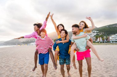 Multiethnic group of young happy friends bonding outside, having fun on summertime vacation - Multicultural cheerful people with summer clothes enjoying summer holidays, concepts about youth, friendship and positive emotion