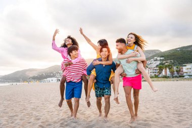 Multiethnic group of young happy friends bonding outside, having fun on summertime vacation - Multicultural cheerful people with summer clothes enjoying summer holidays, concepts about youth, friendship and positive emotion
