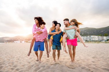 Multiethnic group of young happy friends bonding outside, having fun on summertime vacation - Multicultural cheerful people with summer clothes enjoying summer holidays, concepts about youth, friendship and positive emotion
