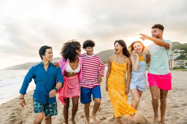 Multiethnic group of young happy friends bonding outside, having fun on summertime vacation - Multicultural cheerful people with summer clothes enjoying summer holidays, concepts about youth, friendship and positive emotion