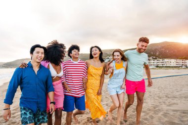 Multiethnic group of young happy friends bonding outside, having fun on summertime vacation - Multicultural cheerful people with summer clothes enjoying summer holidays, concepts about youth, friendship and positive emotion