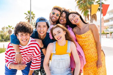 Multiethnic group of young happy friends bonding outside, having fun on summertime vacation - Multicultural cheerful people with summer clothes enjoying summer holidays, concepts about youth, friendship and positive emotion