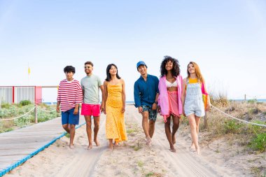 Multiethnic group of young happy friends bonding outside, having fun on summertime vacation - Multicultural cheerful people with summer clothes enjoying summer holidays, concepts about youth, friendship and positive emotion